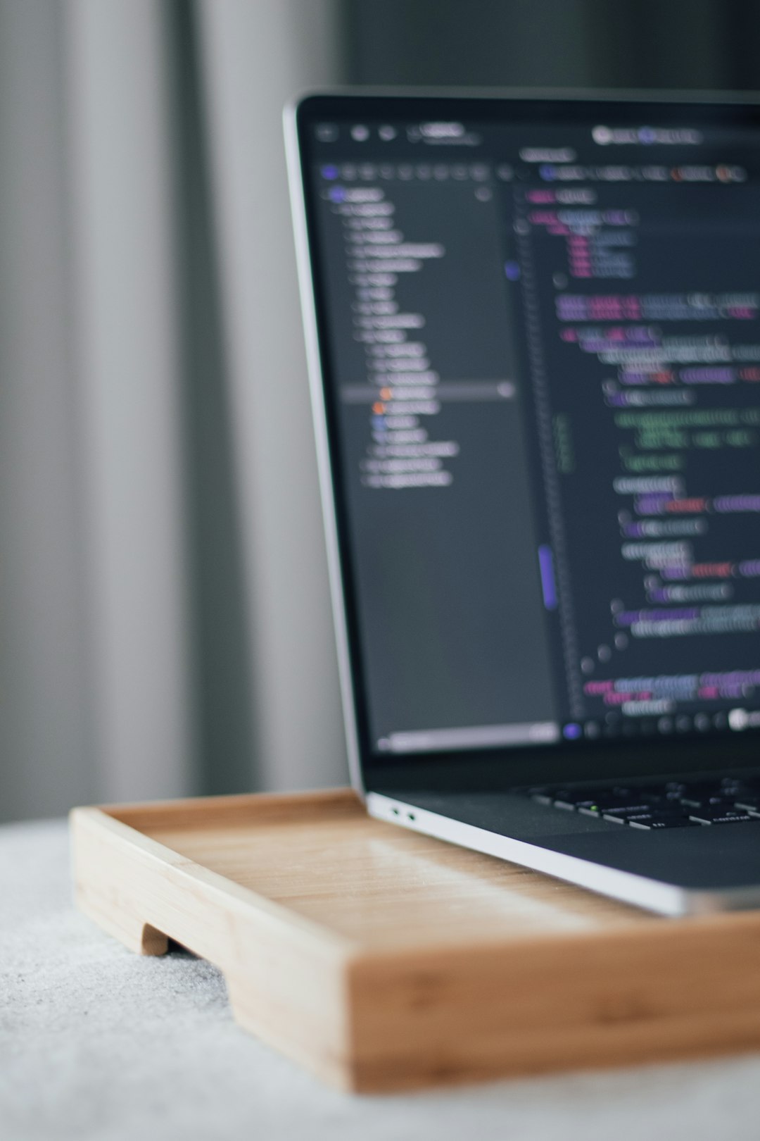 a-laptop-computer-sitting-on-top-of-a-wooden-tray-k0rpr1qmyh0